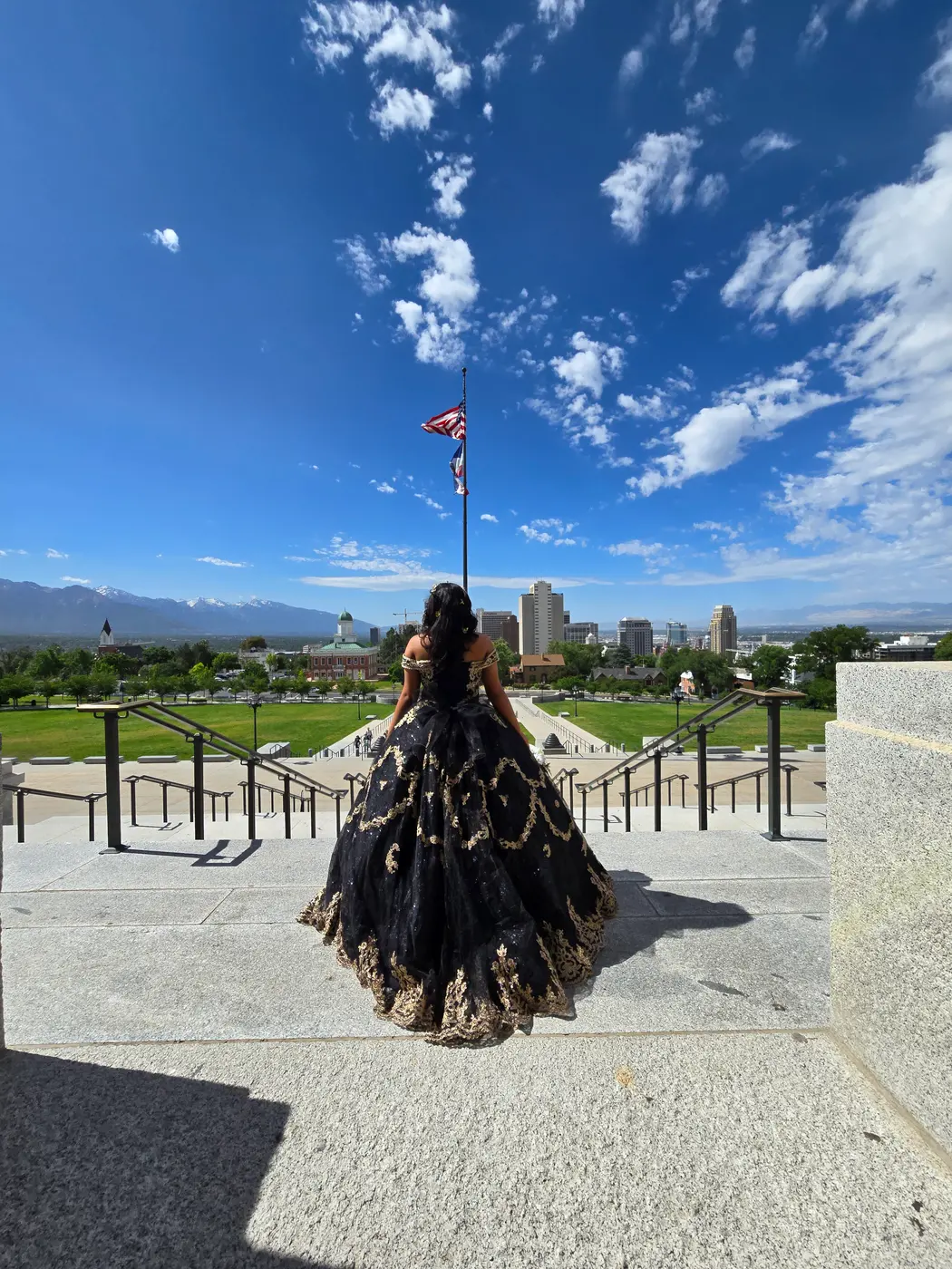 Quinceañera de espaldas mirando Salt Lake City desde las escaleras del Capitolio